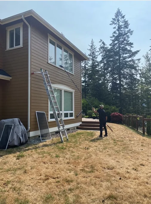 Window cleaner using a water-fed pole on a two-story home