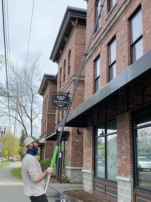 Water-fed pole window cleaning on a brick storefront
